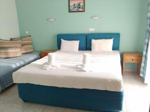 a bedroom with a blue bed and a couch at Porto Vistonis in Lágos