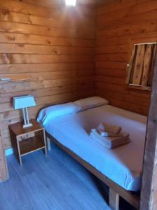 um quarto com 2 camas num chalé de madeira em ECOLODGE CABAÑEROS 