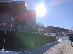 a person walking down a street next to a house at Appartement en rez de jardin vue montagne in Les Contamines-Montjoie