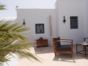 uma sala de estar com uma cadeira e uma mesa em Dar Ennour Djerbahood Erriadh em Houmt Souk