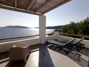a balcony with a table and chairs and a view of the water at Vassiliki Residence Skyros Island in Skiros