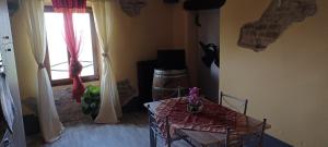 een woonkamer met een tafel en een raam bij Casa Vacanza Dany House in Dogliani