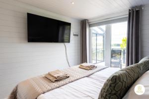 um quarto com uma cama e uma televisão na parede em Villa Eden - Design-Sea-Pool-Sauna-Services em Kemionsaari