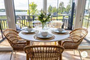 a dining room with a table and chairs on a balcony at Villa Eden - Design-Sea-Pool-Sauna-Services in Kemionsaari