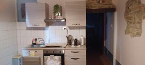 eine kleine Küche mit Spüle und Herd in der Unterkunft Casa Vacanza ElyD House in Dogliani + 5 Fotos