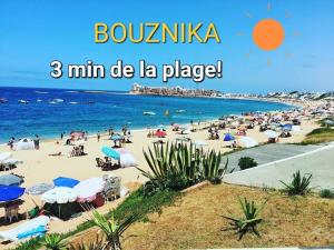 a beach with a large group of people on it at Appartement Costa Bouznika in Bouznika