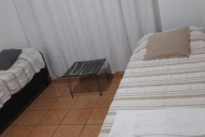 a bedroom with a bed and a chair with a pillow at Dpto Céntrico dpto 4 in Puerto Iguazú