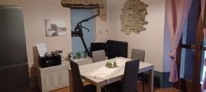 ein Esszimmer mit einem Tisch, einem Tisch und Stühlen in der Unterkunft Casa Vacanza ElyD House in Dogliani