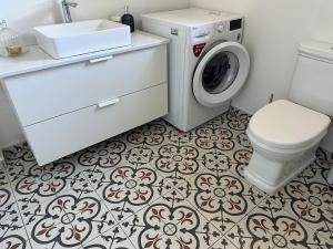 a bathroom with a washing machine and a toilet at Chálari in Raches