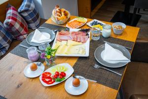 a table topped with plates of food and eggs at Apart-Hotel Laurus Lech in Lech am Arlberg