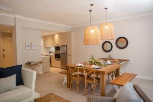 a kitchen and living room with a table and chairs at Blue Coral Beachfront Penthouse in Flic-en-Flac