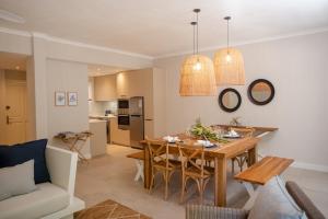 Una cocina y una sala de estar con mesa y sillas. en Blue Coral Beachfront Penthouse, en Flic en Flac