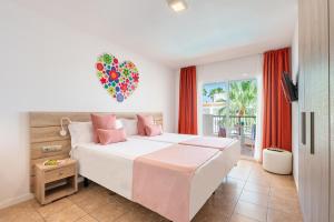 a bedroom with a large bed with a heart balloon on the wall at Hotel Vibra Bossa Flow - Adults only in Playa d'en Bossa