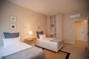 Un dormitorio con dos camas y una mesa con lámpara. en Blue Coral Beachfront Penthouse, en Flic en Flac 37 fotos más