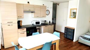 a small kitchen with a table and a microwave at Spacieux studio à 7min de Walibi in Les Avenières