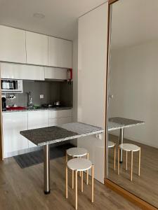 a kitchen with a table and stools in a room at Cais 54 Apartments in Aveiro