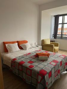 a bedroom with a bed with a quilt on it at Cais 54 Apartments in Aveiro