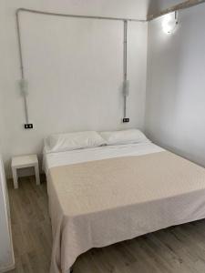 ein weißes Schlafzimmer mit einem Bett und einem Tisch in der Unterkunft Salento Sunny Flat in Aradeo