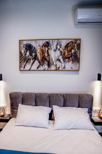 a bedroom with a bed with a painting on the wall at Diamond Suites 32 in Thessaloniki