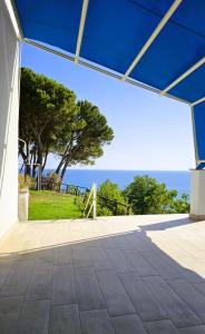 una casa con techo azul y vistas al océano en La fattoria di nonna elvira, en Belvedere Marittimo