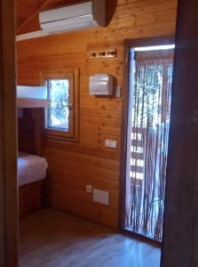 um quarto com uma porta e uma janela numa cabina em ECOLODGE CABAÑEROS 