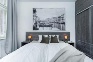 a bedroom with a large white bed and a painting on the wall at Wenceslas square apartment in Prague