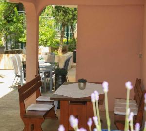 a table and chairs in a patio with a table at Adrian-Apartments-51511-Malinska-Otok-Krk Primorska 21 in Malinska