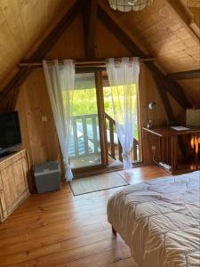 um quarto com uma cama e uma grande janela em Une chambre dans la verdure em Bordeaux-Saint-Clair