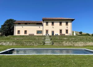 a house with a swimming pool in front of it at Tenuta il Galletto in Casale Monferrato