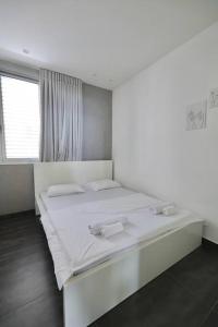 ein weißes Schlafzimmer mit einem großen Bett mit weißer Bettwäsche in der Unterkunft TEL AVIV - Front of the sea in Tel Aviv