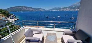 a balcony with chairs and a view of the water at Villa del mare in Herceg-Novi