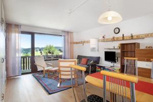 a living room with a table and chairs and a television at Wanderglück in Missen-Wilhams