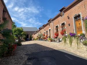 einen Innenhof mit Blumen und Pflanzen in einem Backsteingebäude in der Unterkunft Le Clos de la Belle Loge Location de studio 