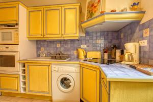 cocina con armarios amarillos y lavadora en Charming apartment in the city center en Sanary-sur-Mer
