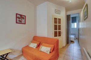una sala de estar con un sofá naranja en una habitación en Charming apartment in the city center en Sanary-sur-Mer