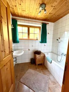y baño con bañera y lavamanos. en Apart Onkl, en Sankt Leonhard im Pitztal