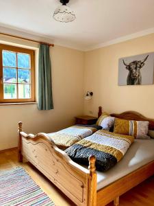 1 dormitorio con 1 cama con una foto de vaca en la pared en Apart Onkl, en Sankt Leonhard im Pitztal