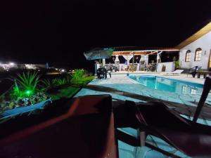 - une vue sur la piscine la nuit dans l'établissement Pousada Pé na Montanha, à Socorro