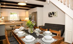 a dining room table with plates and dishes on it at Sawmill Cottage, Coniston Water in Coniston