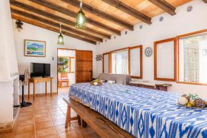 um quarto com uma grande cama azul e branca em Sa Casa des Pintor Miquel Vives 213 em Cala Bona