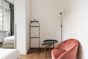 Un dormitorio con una silla rosa y una mesa en Sabotino apartment, en Milán