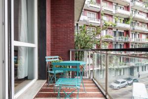 un balcón con una mesa y sillas azules y un edificio en Sabotino apartment, en Milán