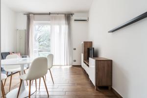 sala de estar con mesa, sillas y TV en Sabotino apartment, en Milán