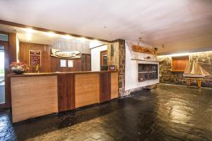 a kitchen with a stove, refrigerator, sink, and cabinets at Panamericana Hotel Ancud in Ancud
