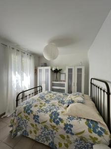 a bedroom with a bed with a floral comforter at Villa piscine confort cosy in Brouilla