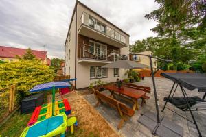 een achtertuin met een tafel en stoelen en een huis bij Willa Arkadia in Pobierowo