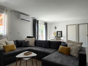 a living room with a couch and a table at Villa piscine confort cosy in Brouilla