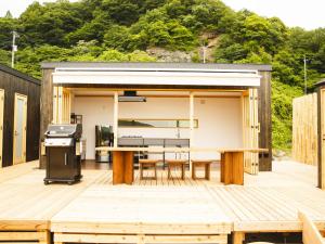 cocina y zona de comedor con barbacoa en la terraza en Hole 37, en Tsukuba