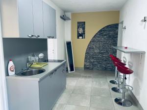 a kitchen with a sink and a brick wall at Apartmani Kotor Varoš in Donja Varoš