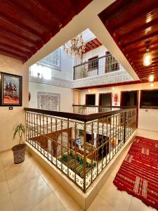 a large room with a balcony with a table at Riad Dar El Mesk in Rabat